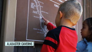 children pointing to a map at alabaster caverns park