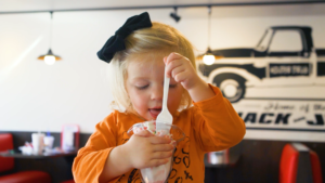 a little girl eating an ice cream sundae