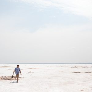 a young boy walking with a shovel at great salt plains