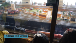 children watching a model train at a museum