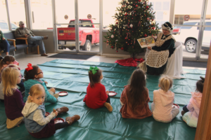 Mrs. Claus reading to a group of children at Christmas time