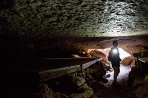 woman with a flashlight in a cave