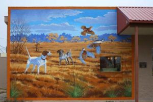 a mural of dogs chasing birds