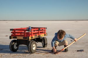 a boy with a wagon digging for crystals at great salt plains